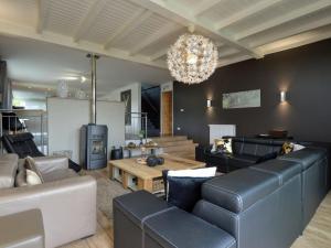 a living room with black and white furniture and a chandelier at Splendid Holiday Home in Stavelot with Sauna in Stavelot