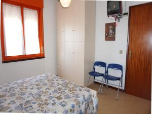 a bedroom with two blue chairs and a bed at Flat in Porto Santa Margherita in Porto Santa Margherita di Caorle