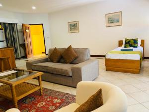 a living room with a couch and a bed at Pieds Dans L’Eau Holiday Apartments in Mahe