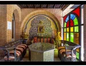 Had Abdallah RhiatPalace with 2 villas and 2 swimming pools in Sidi Abdellah Ghiat的一间设有两张长椅、一张桌子和一个窗户的房间 更多2张照片