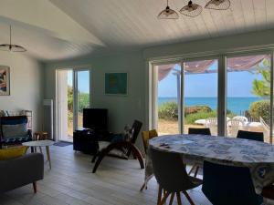 a living room with a table and a view of the ocean at Maison vendéenne rénovée, accès direct plage, terrasses, BBQ, parking gratuit - FR-1-336-123 in Longeville-sur-Mer