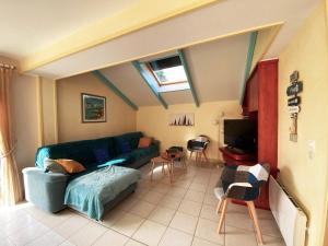 een woonkamer met een bank en een tv bij Maison Arzon, 5 pièces, 9 personnes - FR-1-639-22 in Arzon