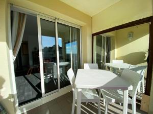 a balcony with a white table and chairs on a patio at Appartement Calme - Arzon, 4 Pers, Parking, Plage à Pied - FR-1-639-25 in Arzon