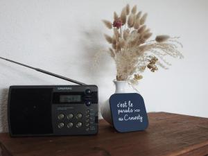 a clock and a vase with flowers in it next to a vase at Appartement Calme - Arzon, 4 Pers, Parking, Plage à Pied - FR-1-639-25 in Arzon