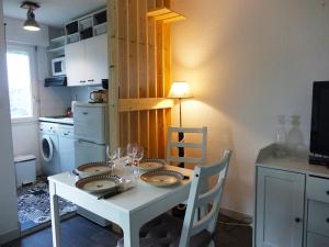 a kitchen with a table with plates and wine glasses at Appartement Calme - Arzon, 4 Pers, Parking, Plage à Pied - FR-1-639-25 in Arzon +8 photos