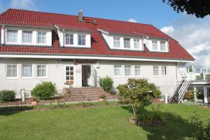 a white house with a red roof at Aparthotel Leuchtfeuer Rügen in Glowe