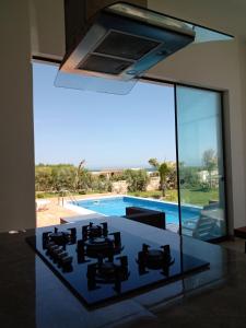 a glass kitchen with a view of a swimming pool at Casa VerdeMar - Vichayito, Perú in Vichayito