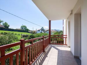 a balcony with a red railing and a view of a yard at Appartement Moderne avec Balcon, Proche Centre et Plage, Piscine et Parking, Hendaye - FR-1-2-399 in Hendaye