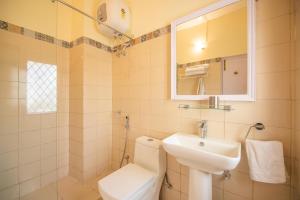 Un baño con lavabo, inodoro y espejo. en Bamboo Grove by VEO - Part of StayVista, en Dehradun 17 fotos más