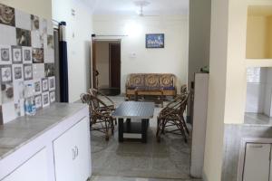 cocina con mesa, sillas y sofá en Corporate Guest House, en Ranchi