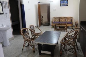 ein Zimmer mit Stühlen, einem Tisch und einem Sofa in der Unterkunft Corporate Guest House in Ranchi