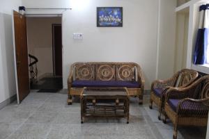 ein Wohnzimmer mit 2 Stühlen und einem Sofa in der Unterkunft Corporate Guest House in Ranchi