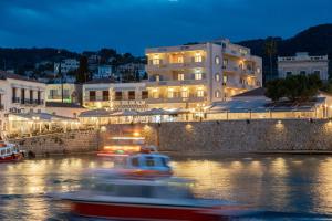a boat in the water in front of a building at Hotel Roumani in Spetses