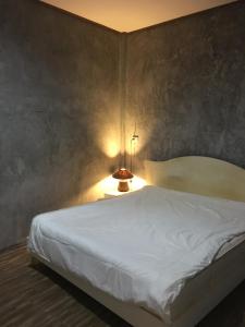 a bedroom with a white bed and a lamp at Fahad Calm House in Ban Not (1)