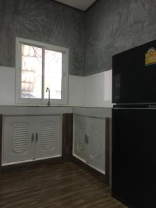 a kitchen with a sink and a refrigerator and a window at Fahad Calm House in Ban Not (1)