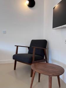 a chair and a table with a tv on a wall at Hotel Roumani in Spetses
