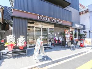 長岡的住宿－HOTEL LiVEMAX Nigata Nagaoka Station，前面有标牌的商店