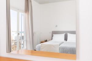 a bedroom with a bed and a large mirror at Hotel Roumani in Spetses