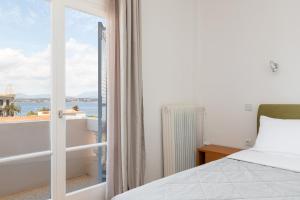 a bedroom with a bed and a view of the ocean at Hotel Roumani in Spetses
