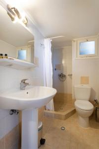 a bathroom with a white sink and a toilet at Hotel Roumani in Spetses