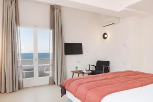 a hotel room with a bed and a view of the ocean at Hotel Roumani in Spetses