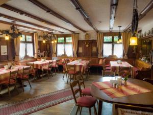 a restaurant with tables and chairs in a room at Gasthof zum Goldenen Kreuz in Wilhelmsdorf
