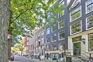 een rij hoge gebouwen in een stadsstraat bij B&B Blossom in Amsterdam