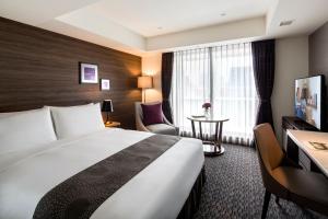 a hotel room with a large bed and a desk at Somerset Ginza East Tokyo in Tokyo