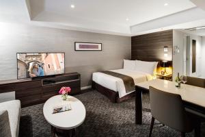 a hotel room with a bed and a flat screen tv at Somerset Ginza East Tokyo in Tokyo
