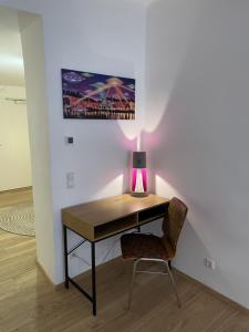a desk with a lamp and a chair in a room at Altstadt Bed&Bike in Gmunden