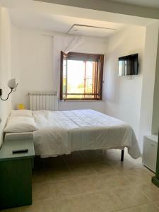 - une chambre blanche avec un lit et une fenêtre dans l'établissement Chiaraluce Country House, à Massignano