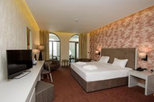a hotel room with a bed and a television at The Grand Gloria Hotel in Batumi