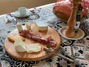 une planche à découper avec du fromage et de la viande sur une table dans l'établissement Hotel Fazenda Castelo Santa Clara, à Lavrinhas