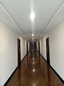 un couloir vide avec des murs blancs et un plafond dans l'établissement Sun Stone Hotel & Club - Jawai, à Sheoganj