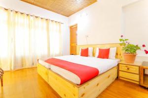 una camera con letto in legno e cuscini rossi di Semskit Guest House a Leh Altre 5 foto
