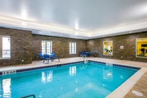 una gran piscina en un edificio con sillas azules en Comfort Suites Fishkill near Interstate 84, en Fishkill