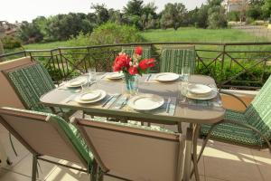 een tafel met een vaas met bloemen op een balkon bij Kima: Relaxing beach home next to sparkling waters in Nea Makri