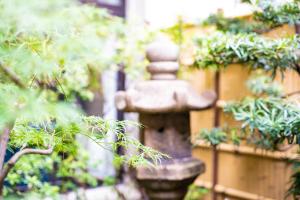 a stone fountain in a garden with plants at 京都駅前ひふみ旅館（HifumiRyokan Kyoto station) in Kyoto