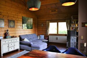 a living room with a couch and a table at Norwegisches Blockhaus mit Gartensauna in Bad Münstereifel