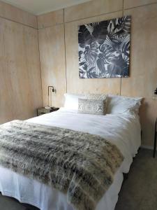 um quarto com uma grande cama branca e um cobertor em Relax in Kenmure em Dunedin