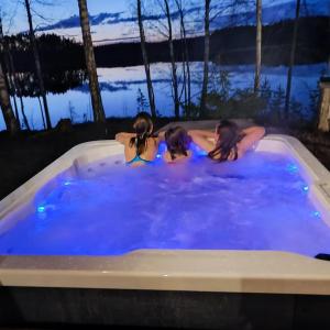three girls in a jacuzzi tub at night at Villa Joutsen with jacuzzi in Vuoriniemi