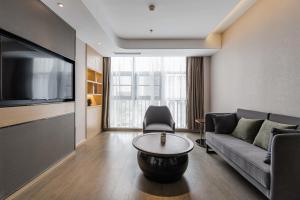 a living room with a couch and a flat screen tv at Atour Hotel Yancheng ETDZ in Yancheng +20 photos