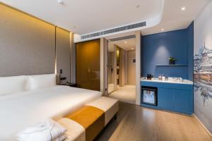 a bedroom with a large bed and a bathroom at Atour Hotel Nanjing Olympic Sports Center Tianhe Plaza in Nanjing