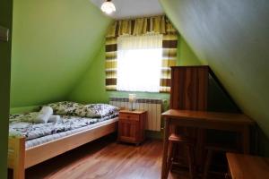 a green bedroom with a bed and a window at Willa Stachowiec in Biały Dunajec