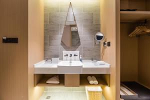 a bathroom with a white sink and a mirror at Atour Hotel Nanjing Olympic Sports Center Tianhe Plaza in Nanjing +17 photos
