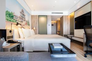 a hotel room with a large bed and a desk at Atour Hotel Lanzhou Anning Zhonghai Plaza in Lanzhou