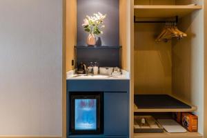 a small kitchen with a sink in a cabinet at Atour Hotel Suzhou North High-Speed Railway Station in Suzhou