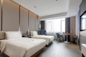 a hotel room with two beds and a desk at Atour Hotel Jinan High-Speed East Railway Station in Jinan