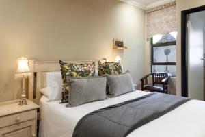 sypialnia z łóżkiem, krzesłem i oknem w obiekcie InnJoy Boutique Hotel w mieście Centurion