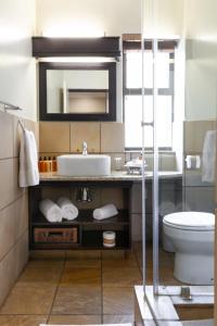 a bathroom with a sink and a toilet at InnJoy Boutique Hotel in Centurion